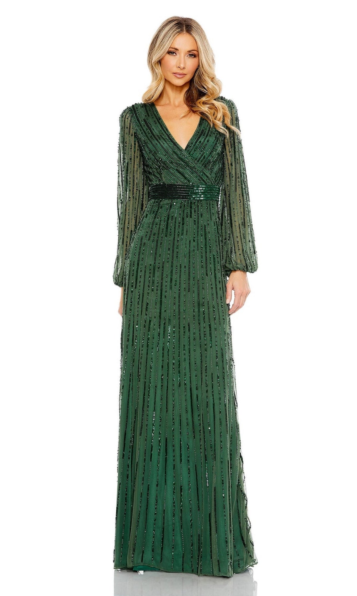 A woman stands facing forward against a plain white background, wearing the Long Formal Dress 5718 by Mac Duggal—a green floor-length gown with a V-neckline and vertical sequin embellishments.